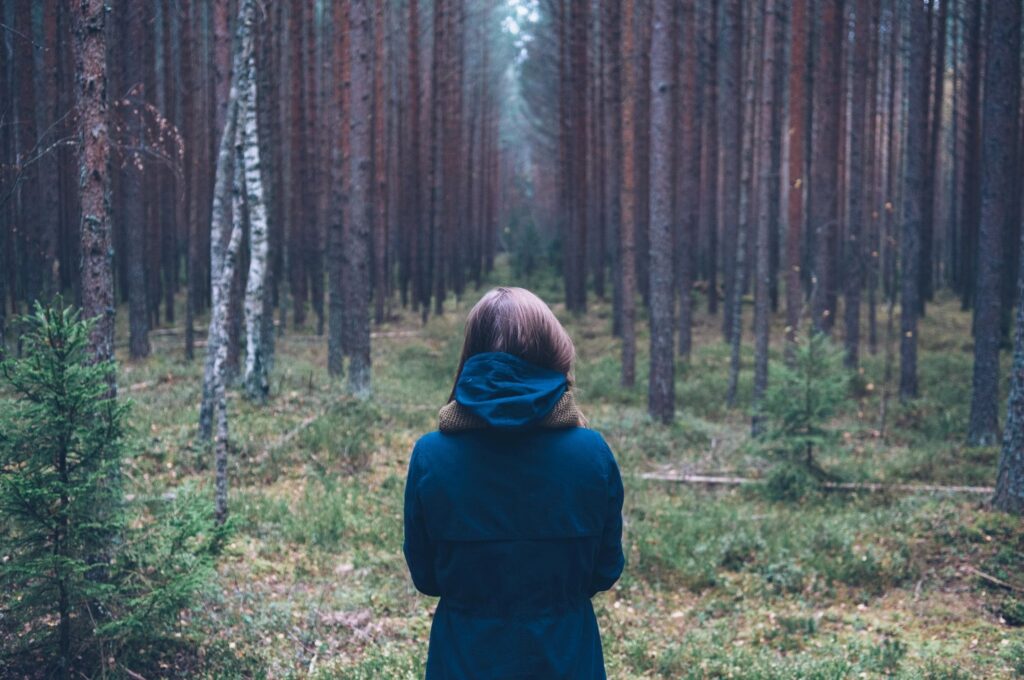 woman staring into forest