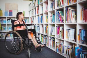 Child in a wheel chair looking at the book shelf