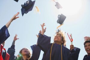 Graduates celebrating and tossing their caps in the air